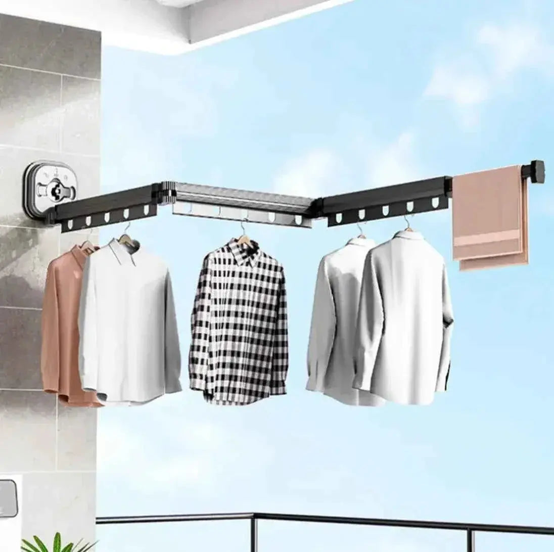 Wall-mounted retractable clothes drying rack with shirts and towels hanging outdoors