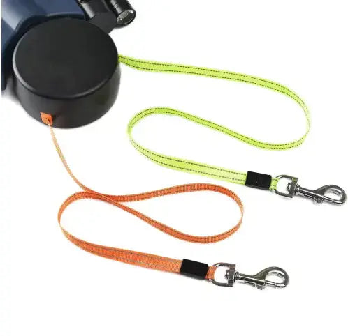 Dual retractable dog leash with neon green and orange leads and metal clips