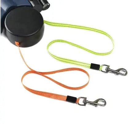Dual retractable dog leash with neon green and orange leads and metal clips