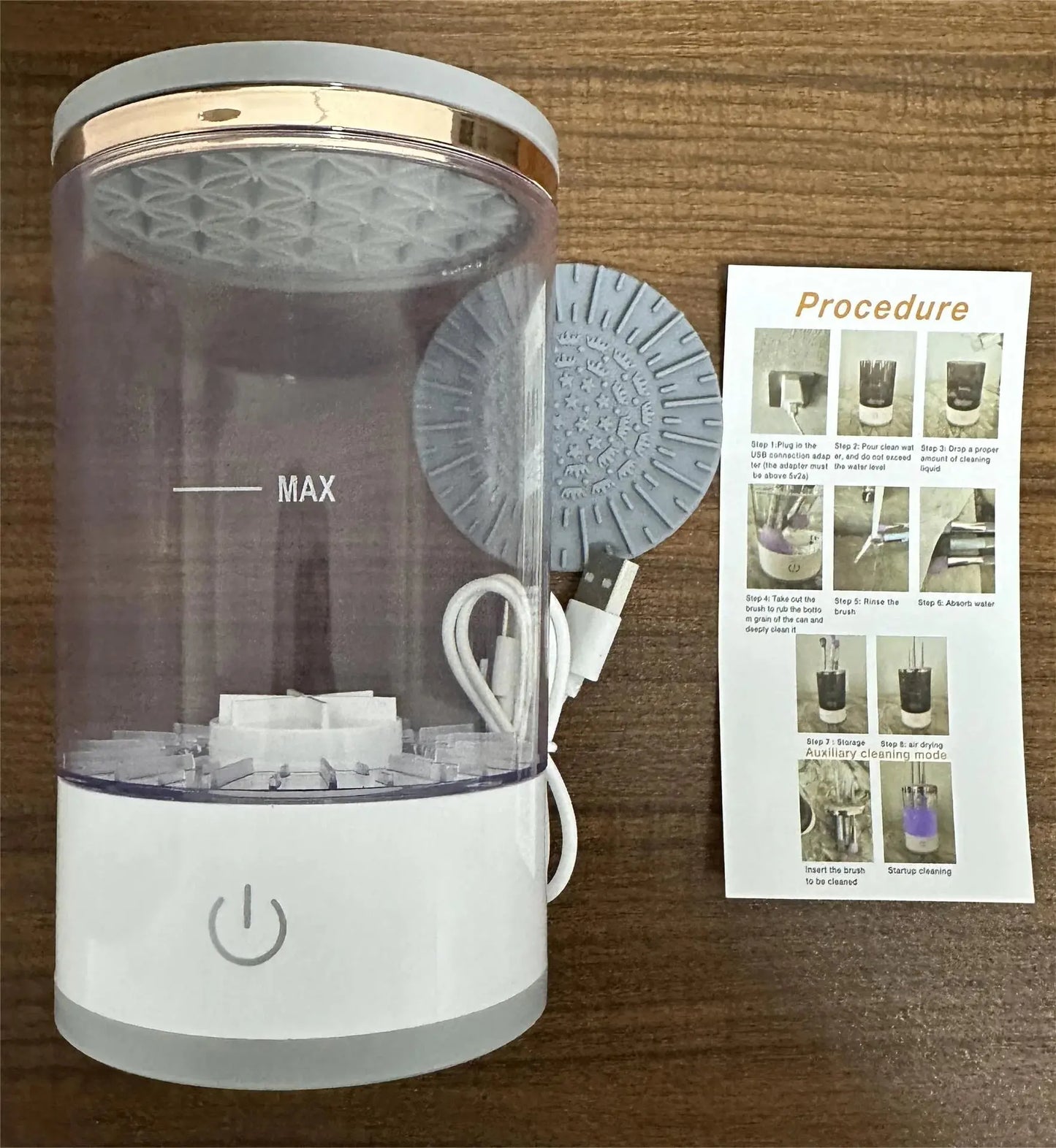 Automatic makeup brush cleaner kit with USB cable, cleaning pad, and instruction sheet on wood table