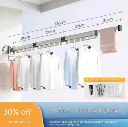 Wall-mounted retractable clothes drying rack with windproof hanging holes, holding shirts.